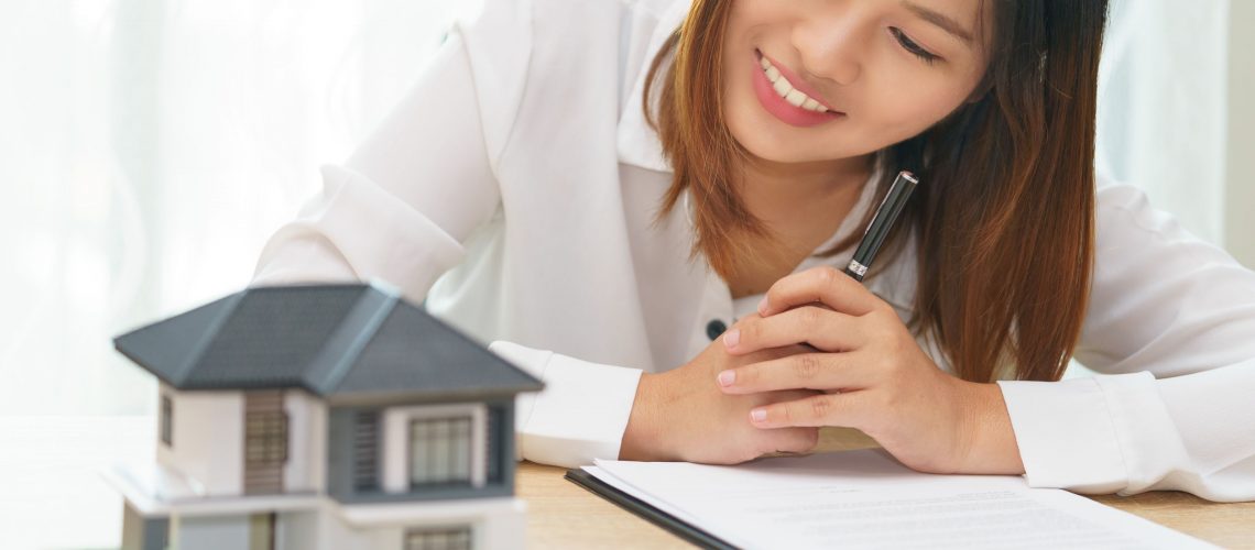 Smile woman looking at home and getting ready to sign contract for investment - satisfy in home